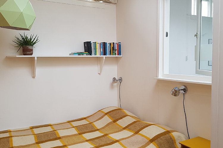 De aparte slaapkamer (10 m2) heeft twee eenpersoons boxspring bedden en een kledingkast. Je kunt een raam opendoen naar de woonkamer.